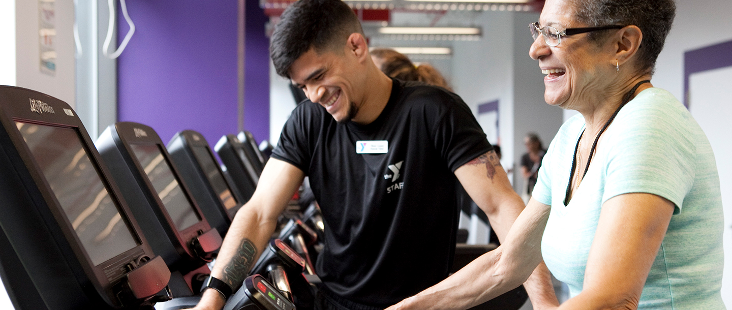 A YMCA personal trainer works with a member on the treadmill