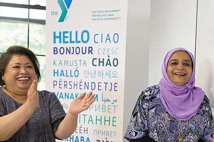 Two women smiling in Flushing YMCA new americans welcome center english classroom