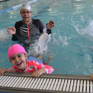 Kids in adaptive swim class for students with special needs at indoor swimming pool