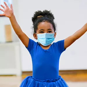 A girl in a mask at ballet class at the YMCA