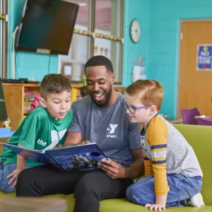 teacher reading book to two kids