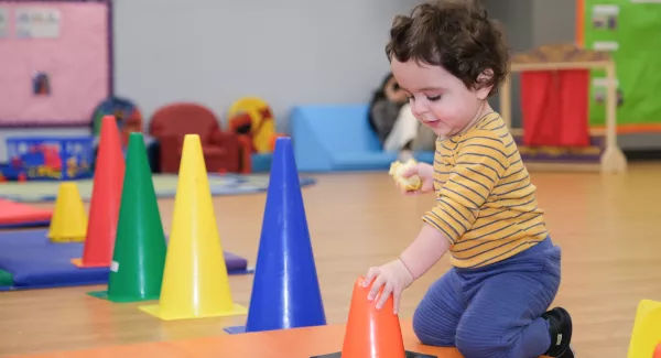 kid in striped shirt playing with cones