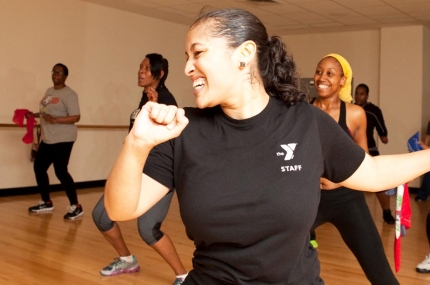 A YMCA instructor leads a group dance class.