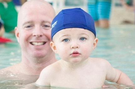 Dad and baby swimming in Rockaway YMCA indoor pool