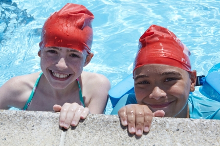 two kids smiling in outdoor pool
