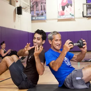 Two Y members work out in a group fitness class.