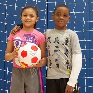 Girl and boy playing soccer at the YMCA in Brooklyn