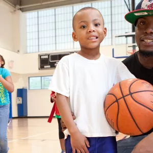 Family playing basketball together during rec time at the YMCA