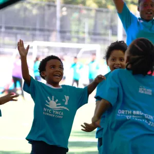 Kids play under a parachute at the North Brooklyn YMCA summer day camp.