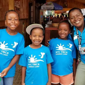 Four kids and a staff member at a YMCA summer day camp.