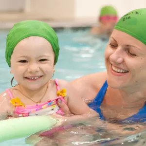 Mom and baby swimming in YMCA indoor pool