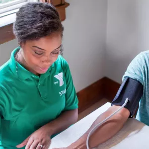 A YMCA staff member takes a man's blood pressure.