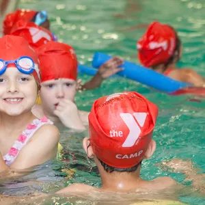 Summer camper swimming at YMCA pool