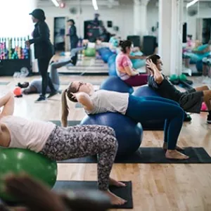 Workout class on yoga mats using balls to do core training exercises at Rockaway YMCA fitness studio