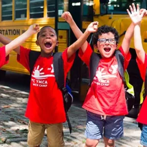 Summer campers with arms up on YMCA field trip