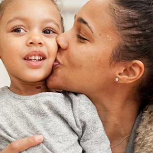 Mom kisses daughters cheek